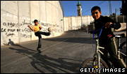 Palestinian boys play under Israel's separation barrier in May 2008