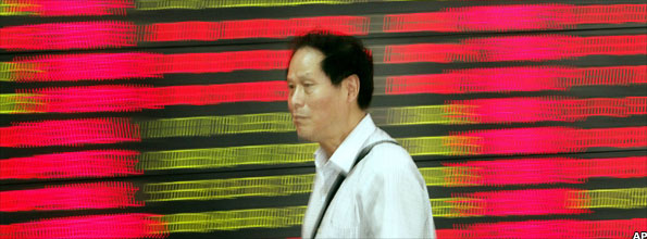 Man walking past stock price monitor in Shanghai