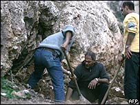 Policiais observam escavadeira em vala com 20 corpos encontrada no Líbano