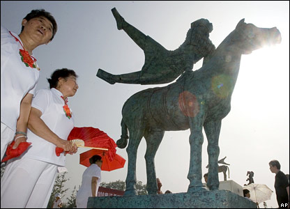 Nghệ sĩ biểu diễn TQ đứng cạnh tác phẩm điêu khắc ở Bắc Kinh.