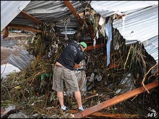 Hombre intenta salvar sus enseres en vivienda destruida por Agatha en Tegucigalpa, Honduras