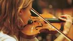A young woman playing a violin