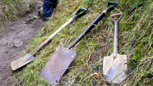 Spades and a shovel lying on the ground