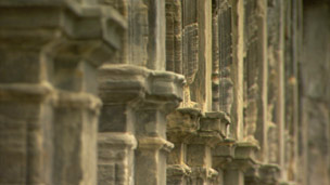 Detail of stonework forming arches supported by columns.