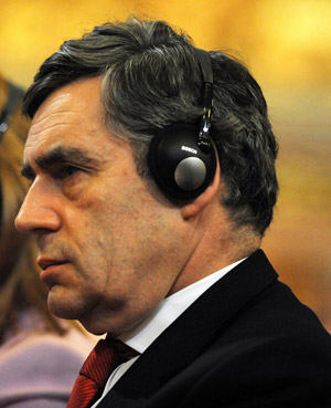 Gordon Brown wearing a large unfashionable headphone