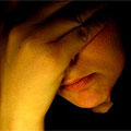 Close-up image of a woman with a hand covering her face, signifying depression