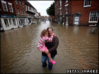 mãe e filha andando em rua inundada