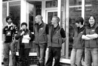 Y teulu'n gwrando'n astud wrth i Ceridwen Richards groesawu'r dorf luosog i agoriad swyddogion y siop a'r caffi yng nghwmni'r gwr gwadd, Rhys op Hywel.