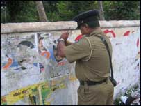 police officer removeing poster 