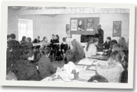 Llond dosbarth o blant yn brysur yn ysgrifennu