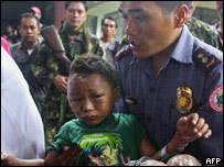 Policial carrega menino ferido em explosão nas Filipinas