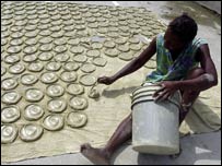Haitili bir kadın güneşte kil ve yağdan yapılan 'çörekleri' kurutuyor