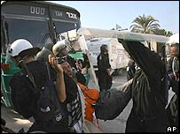 Izraelští vojáci odnášejí osadníka