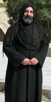 Father Irenaeus, Coptic monk in full black robe and headscarf with short beard