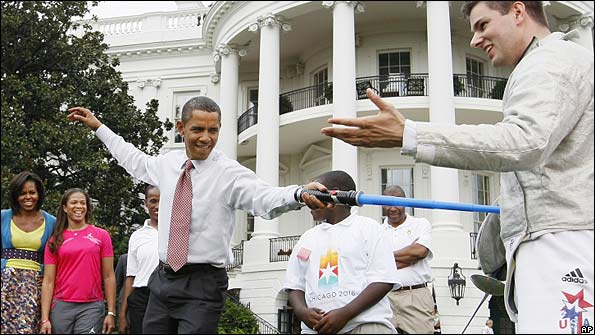 President Barack Obama uses a light saber against Olympic fencer Tim Morehouse