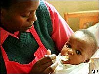 Enfermeira alimenta bebê africano com Aids