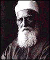 Black-and-white photo of Abdu'l-Baha, an ageing man with a long white beard