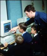 Kids being taught how to use a computer