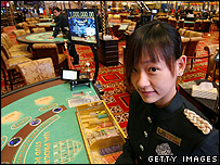Một nhân viên đứng chờ cạnh bàn chơi poker tại một sòng bạc ở Macao