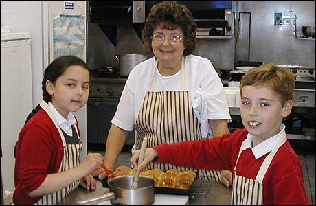 Pat Baggott helps pupils Mary and Charlie cook
