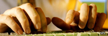 A man's fingers typing on keyboard