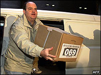 Voluntário do tribunal eleitoral carrega urna com assinaturas