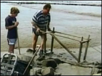 Fisherman pushing wooden mud horse