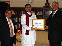 Shivshankar Menon (R) handing over aid to Basil Rajapaksa while Indian High Commissioner looks on