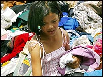 دختری در تايلند لباس های اهدايی را ورانداز می کند