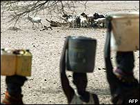 Mulheres africanas transportando recipientes com água