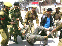 मारे गए चरमपंथी का शव ले जाते सुरक्षाकर्मी