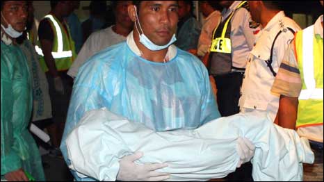 عامل إغاثة يحمل جثة طفل من ضحايا التسونامي إلى مستشفى توبوا تاماسيس في أبوا عاصمة ساموا