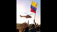 Partidários de Hugo Chávez mostram a bandeira venezuelana enquanto seu helicóptero deixa o palácio presidencial de Miraflores, em Caracas, em 14 de abril de 2002