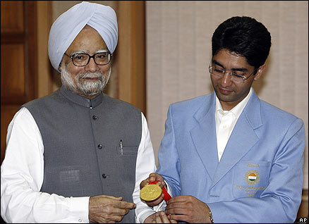 Indian shooter Abhinav Bindra shows his Olympic gold medal, to Indian Prime Minister Manmohan Singh