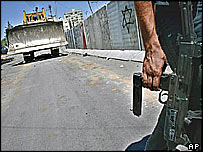 Soldado israelense patrulha muro em construção que divide Cisjordânia