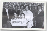 Nesta Williams (mam Guto) a'i ddwy chwaer Anni a Siân yn cyflwyno siec i ymgynghorwyr a nyrsys o Ganolfan Walton Lerpwl