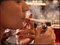 زنی سيگار آتش می زند