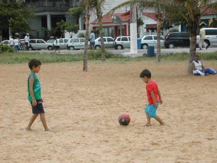 My son and friend playing football at the Praia da Costa beach
