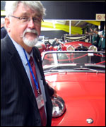 Museum curator Michael Penn standing by a red car