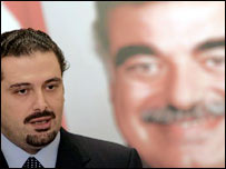 Saad Hariri, vencedor da eleição no Líbano, dá entrevista em frente a cartaz com imagem de seu país, o ex-premiê assassinado Rafik Hariri