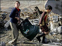 Hai thiếu niên Palestine đi qua một khu vực đổ nát ở Rafah hôm 30.12