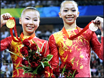 Nữ vận động viên Trung Quốc Hà Khả Hân (bên trái) được cho là mới 14 tuổi thấp hơn 2 tuổi so với quy định