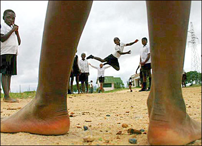 A young girl leaps framed by another childs calves