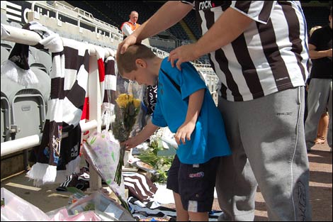 Young fan laying flowers at St James' Park to pay tribute to Sir Bobby Robson