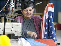 Mulher eslovaca costura bandeiras da Eslováquia e dos Estados Unidos