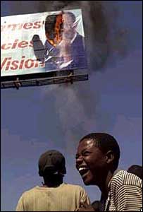 Haitianos botam fogo em outdoor com foto do ex-presidente Aristide (foto AP)