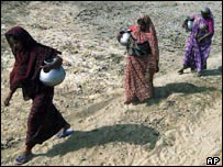 mulheres buscam água em país afetado por tsunami
