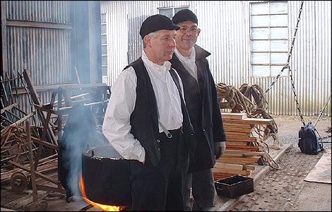 Engineers, Peter Stoddart and Tom Jones keep warm by the fire