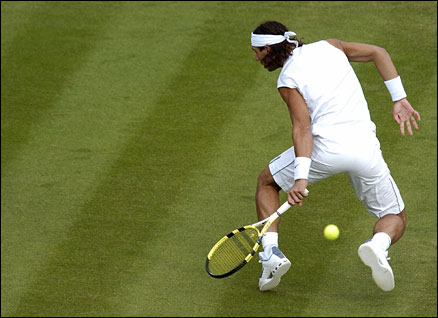 Spain's Rafael Nadal fires a spectacular return between his legs