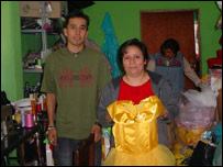 A costureira Maria Hernandez Collin, com seus ajudantes, mostra uma das fantasias que fabrica